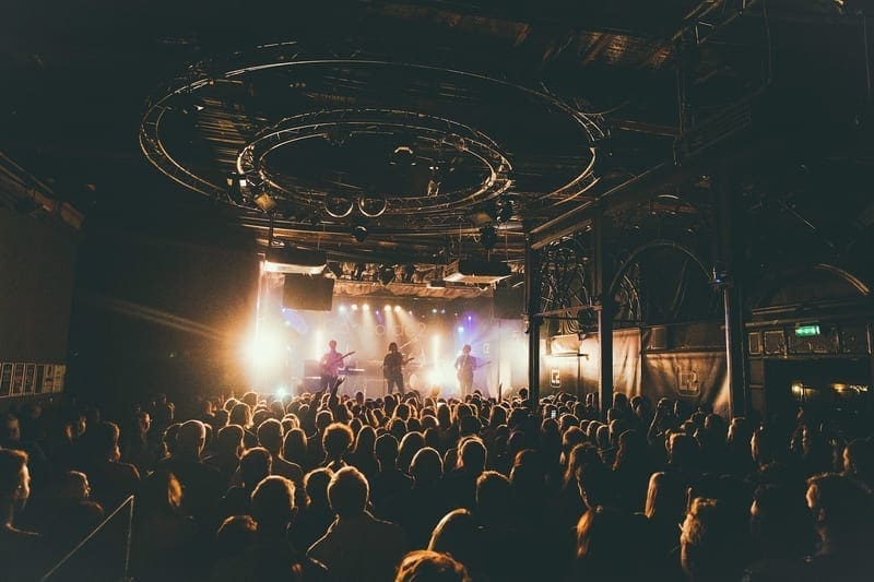 A crowd of people in a music venue watching a band on stage