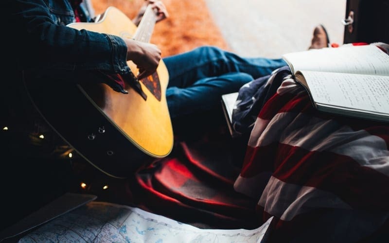 Guitar Songwriting in denim with map and blankets