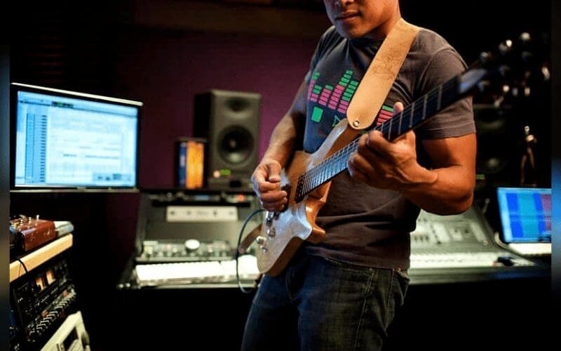 man recording guitars using plug-ins