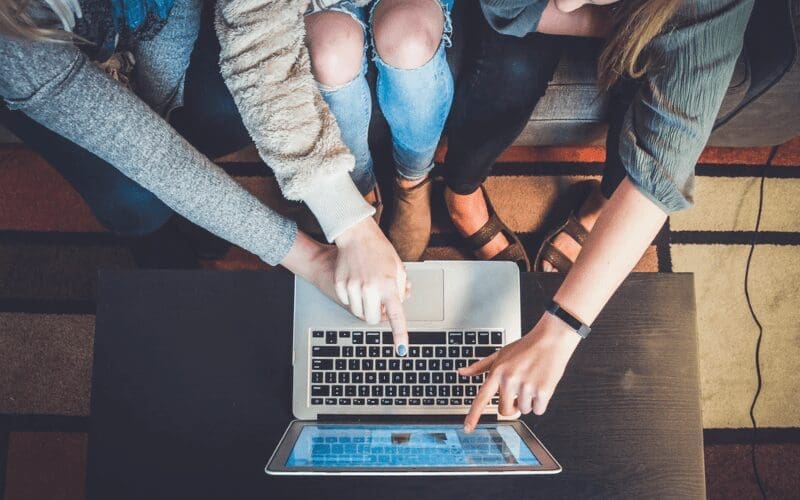 3 People checking out a website on a laptop. Fiverr