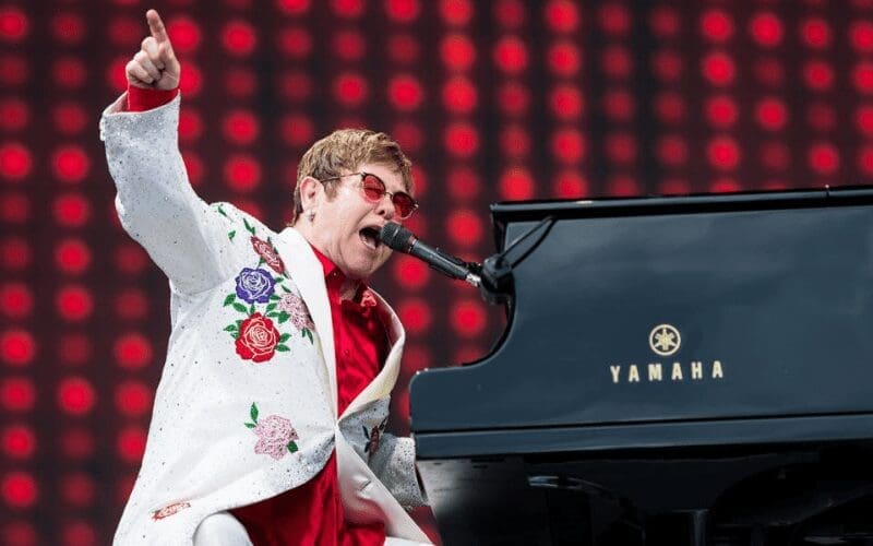 elton john performing playing piano