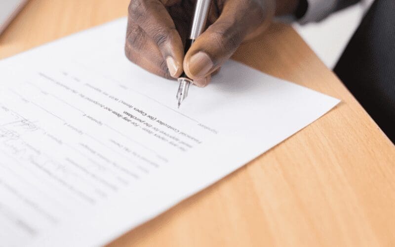man signing a contract music split sheet