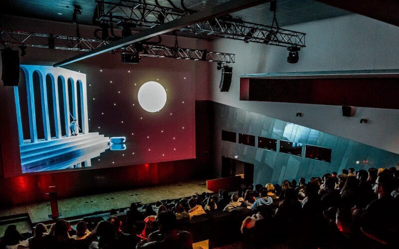 A crowd watching an animated film at Raindance film festival.