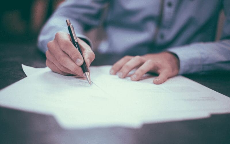 man signing music split sheets