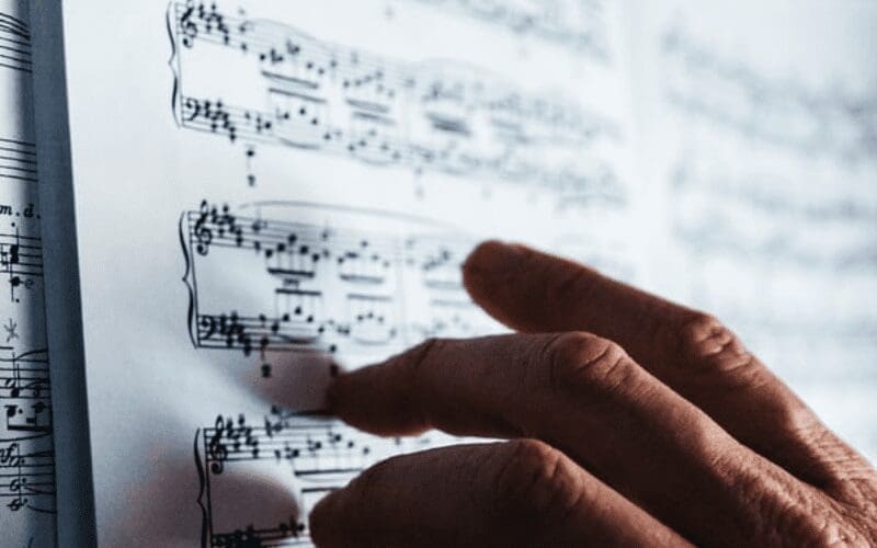 man writing sheet music