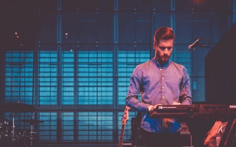 man playing keyboard with microphone