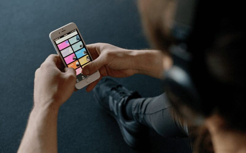 A person scrolling through Spotify using their iPhone.